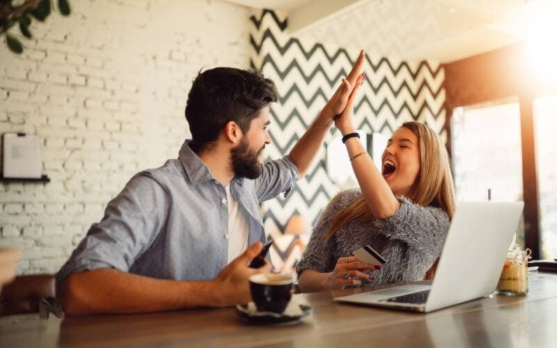Young couple celebrating after refinancing their mortgage loan
