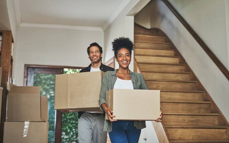 Young couple moving boxes into their new home